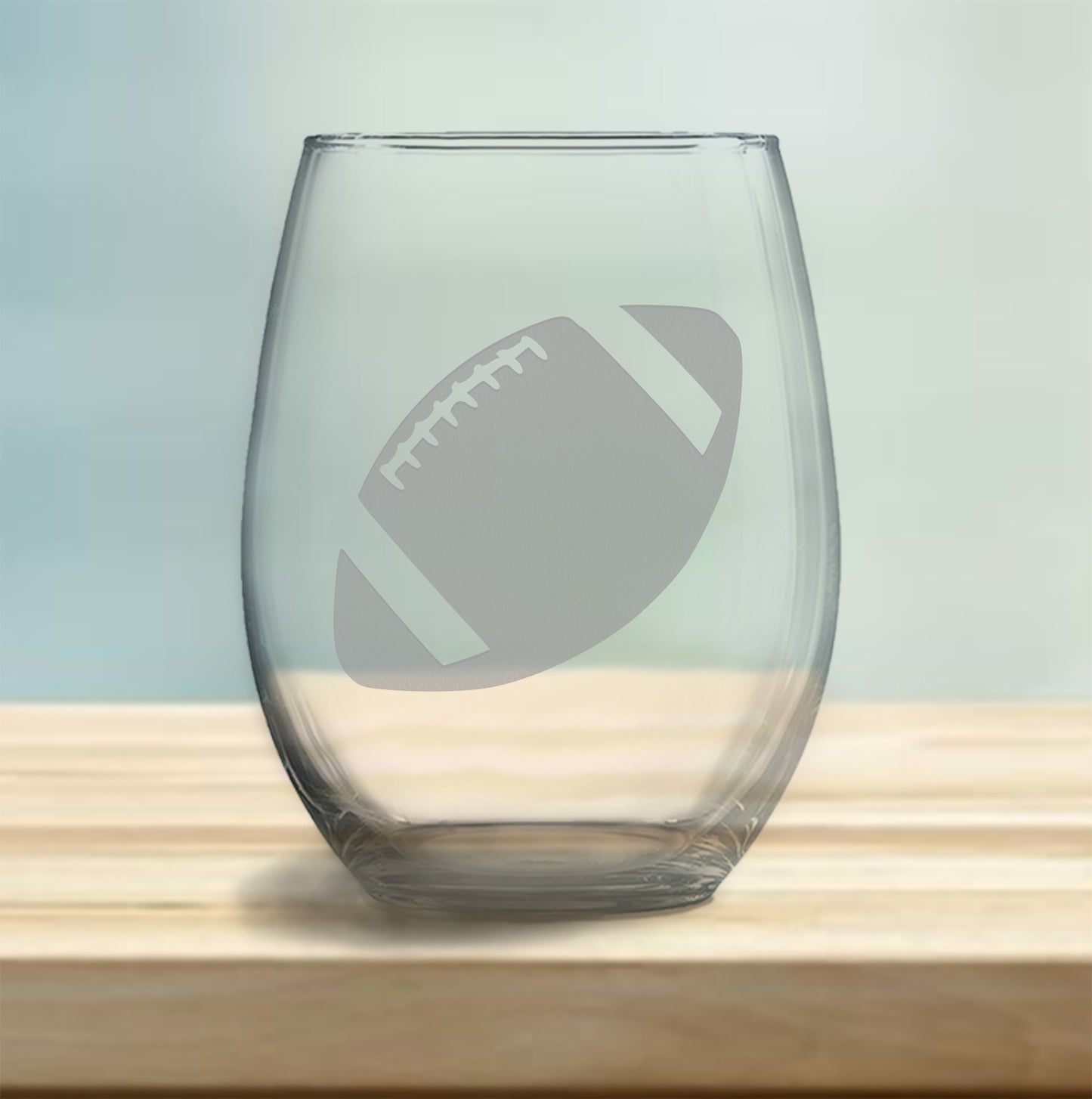 Stemless wine glass with etched football design – perfect gift for football fans, ideal for enjoying wine with a sporty, athletic touch.