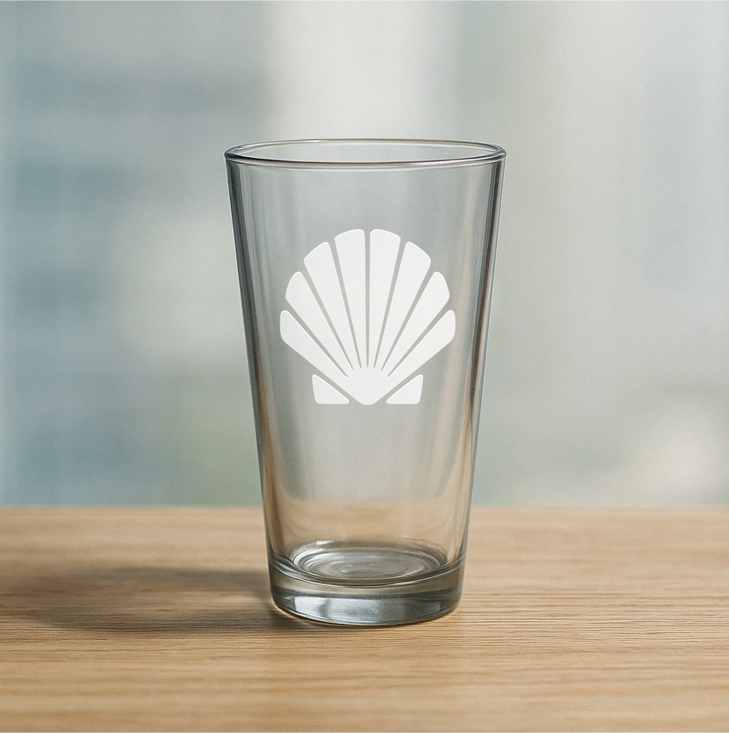 Custom etched pint glass featuring classic sea shell design – personalized beer glass gift for beach lovers and coastal decor fans