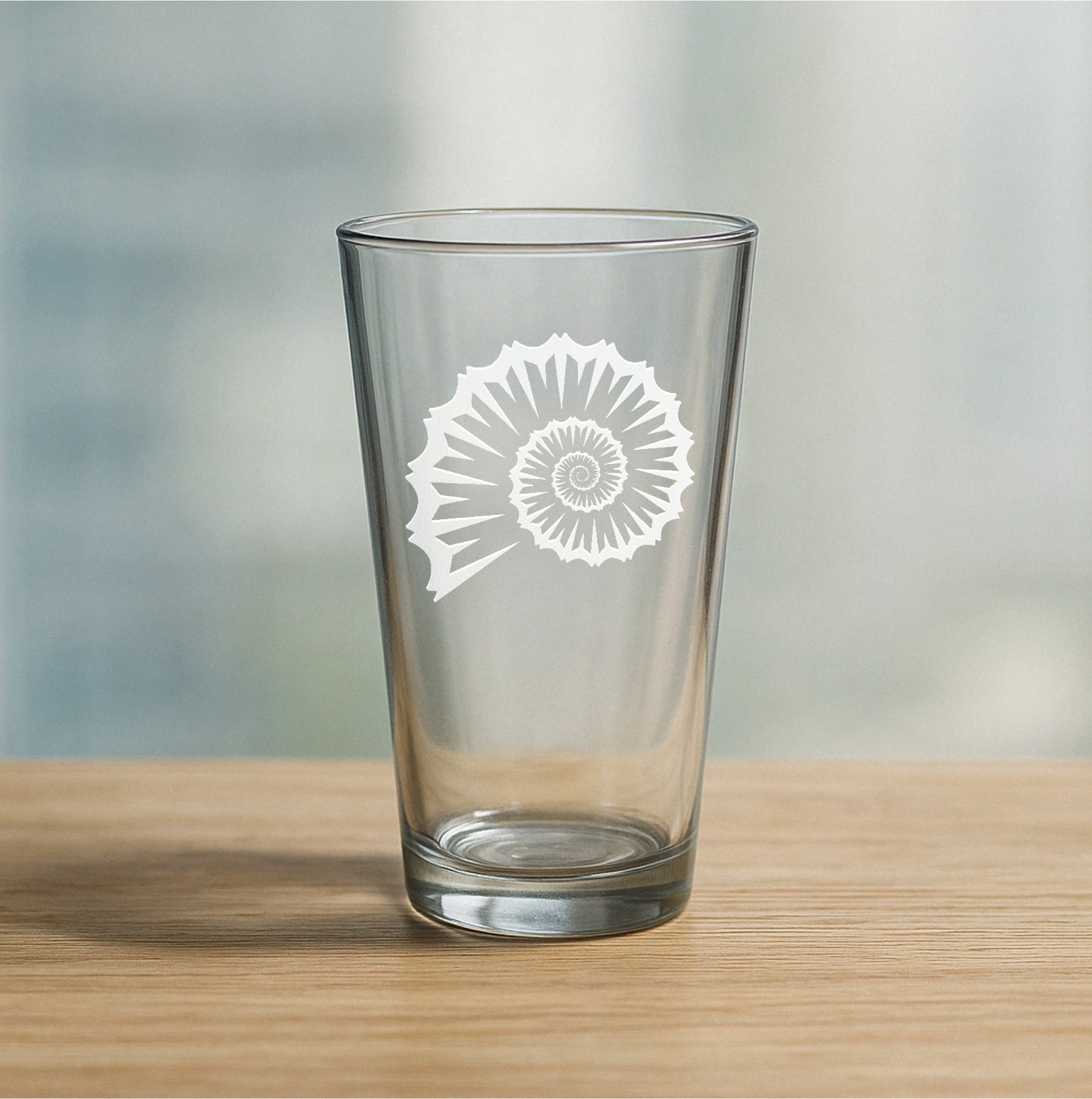 Custom etched pint glass featuring swirly seashell design – personalized beer glass gift for beach lovers and coastal decor fans